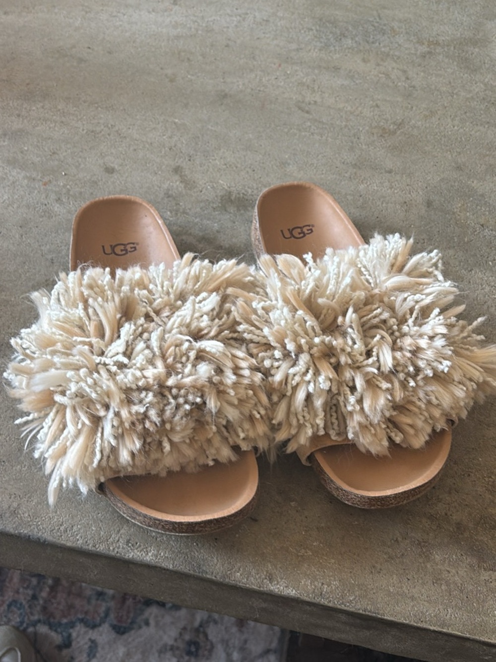 UGG Cindi slides in a cream color, featuring distinctive shaggy yarn pom A-3